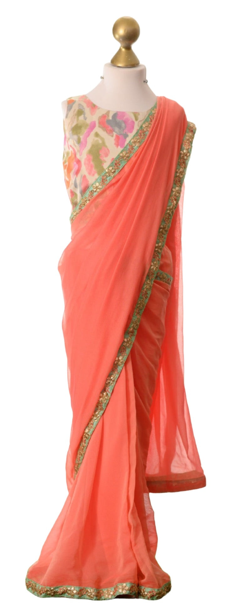 Little girls saree in a coral orange pink colour with a contrasting saree blouse in satin. 